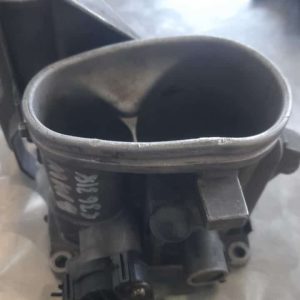 Top-down view of a BMW E36 318 throttle body showing throttle linkage and air intake opening.Top-down view of
