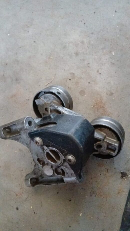 Front angled view of a new Ford Ranger WL 2.5 tensioner pulley showing pulley and mounting bracket.Front angle