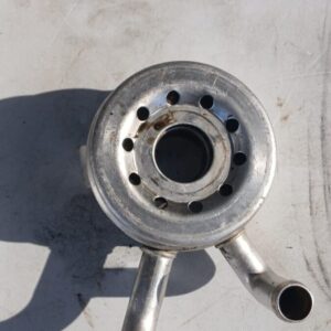 Front angle view of a car oil cooler featuring multiple fins and inlet/outlet pipes, displayed on white backgr