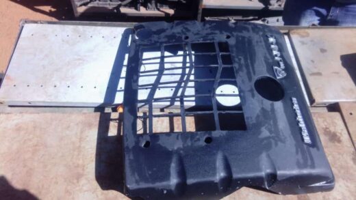 Front angle view of a used engine cover for a 2006 Mahindra Scorpio, showing mounting points and surface detai