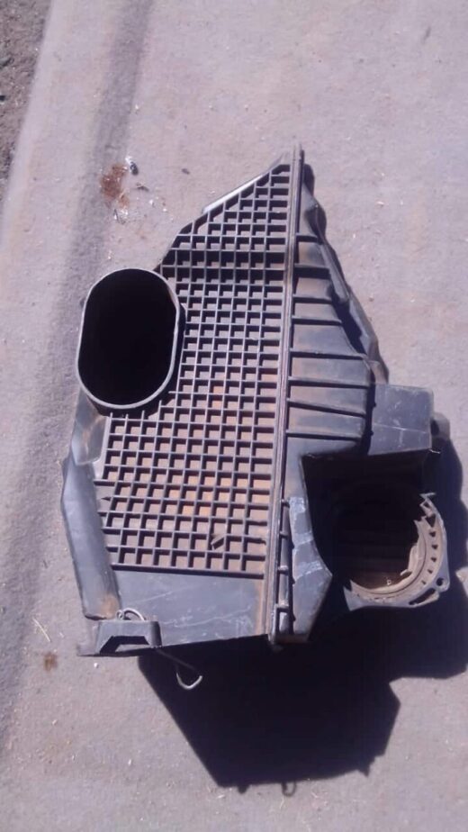 Used air filter housing for Renault Duster shown from a top angle highlighting the housing and attached hose.U